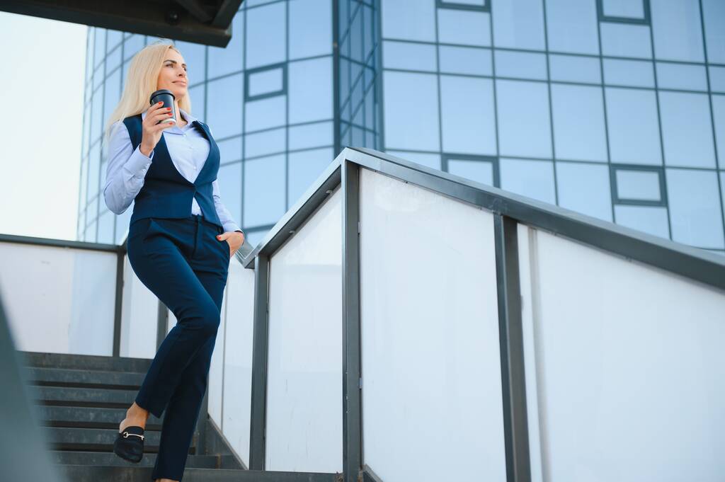 Közelkép egy komoly üzletasszonyról kék öltönyben, aki a városban áll.. - Fotó, kép
