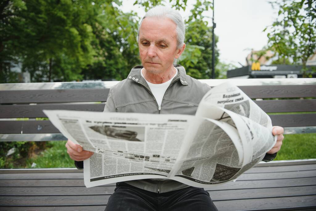 Retrato de homem sênior lendo no banco durante o dia de verão - Foto, Imagem