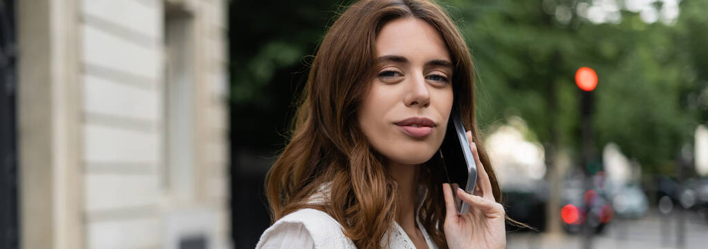 Μπρουνέτ γυναίκα μιλάει στο κινητό τηλέφωνο σε αστικό δρόμο στο Παρίσι, πανό  - Φωτογραφία, εικόνα