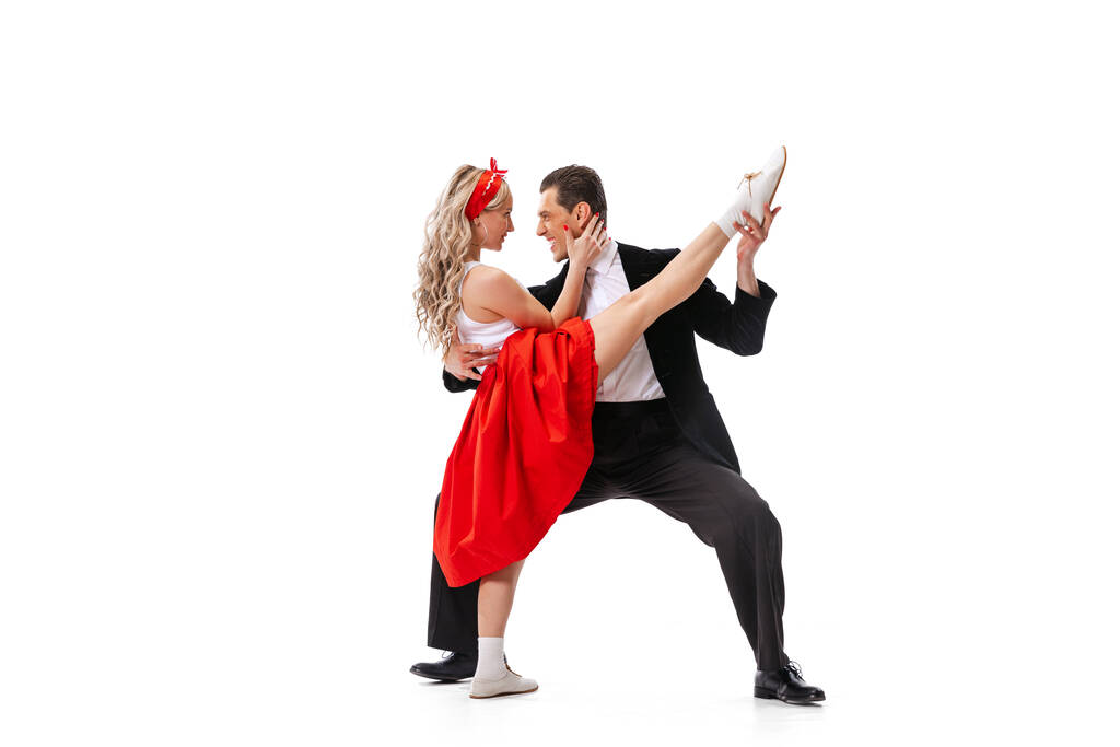 Élet és érzelmek. Izgatott fiatal pár táncosok vintage retro stílusú ruhák tánc társadalmi tánc elszigetelt fehér háttér. Időtlen hagyományok, 60-as, 70-es évek amerikai divat stílus. - Fotó, kép