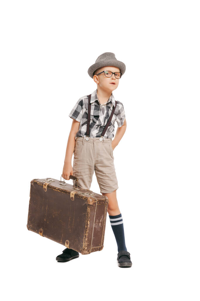 Літні канікули. Портрет милий маленький хлопчик, щаслива дитина в окулярах і капелюх з ретро валізою ізольовані на білому фоні студії. Концепція дитячих емоцій, вираження обличчя
 - Фото, зображення