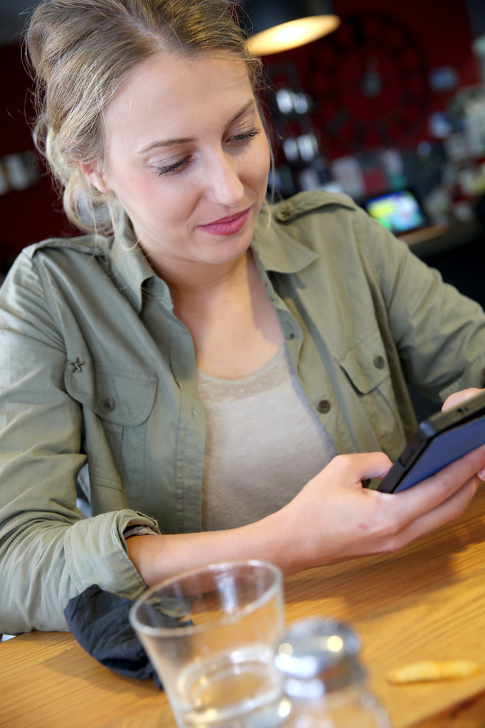 Student meisje in lounge gebruikend smartphone - Foto, afbeelding