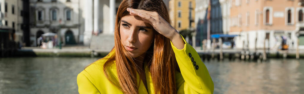 jovem ruiva segurando a mão acima dos olhos e olhando para longe em Veneza, banner - Foto, Imagem