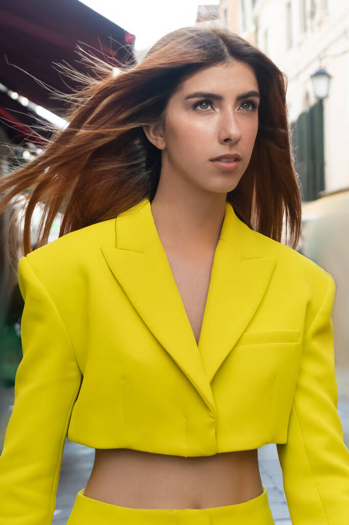 young redhead woman in yellow crop jacket on blurred street in Venice - Photo, Image