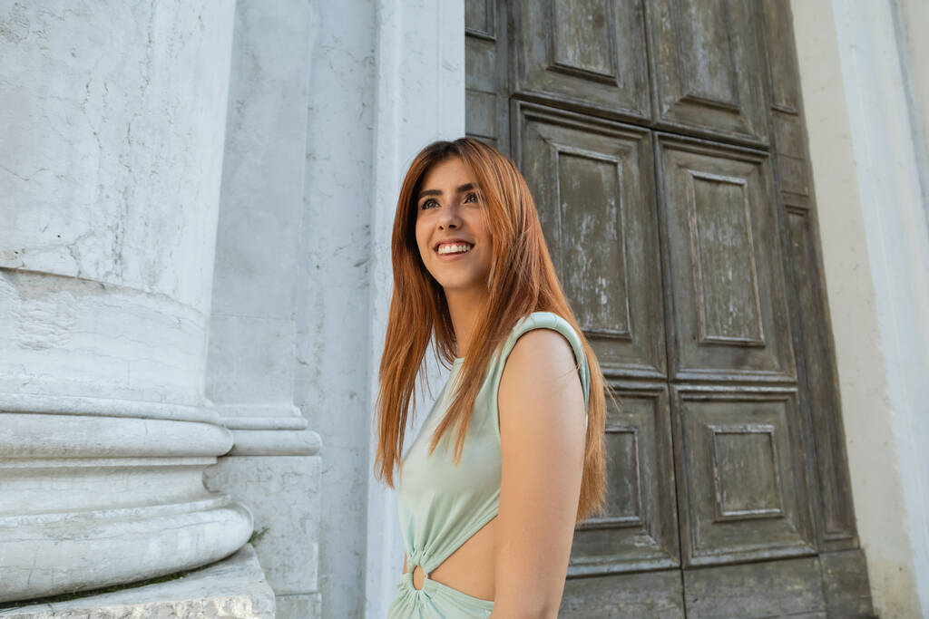 веселая женщина с рыжими волосами, смотрящая на улицу в Венеции - Фото, изображение