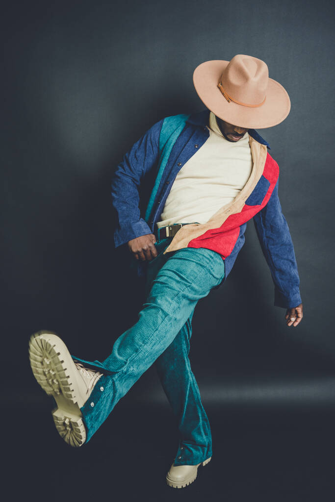 An African American man from US in a hat and casual outfit posing in a photo studio - Photo, Image