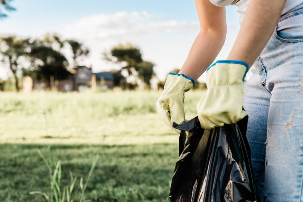 Um close-up de uma pessoa com luvas segurando um saco preto para o lixo. Foco seleccionado. Argentina. - Foto, Imagem