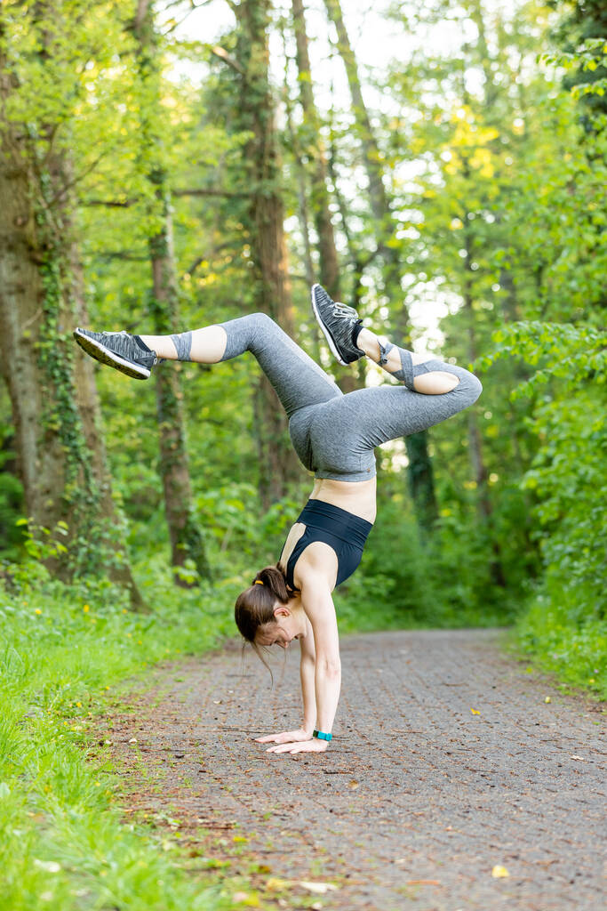 Mladá běloška, která dělá handstand v přírodě jako fitness cvičení - Fotografie, Obrázek