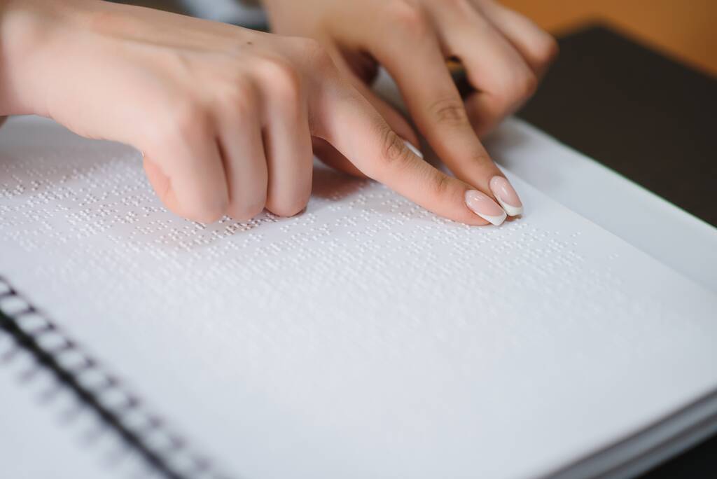 Niewidoma czytać książki napisane w alfabecie Braille'a. Dotknij palcem, aby Braille'a kod z bliska. - Zdjęcie, obraz