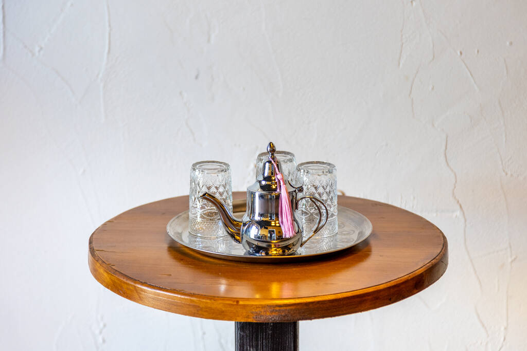 Gümüş çaydanlık ve cam çay fincanlarının doğu çay içme şeklinin keyfini çıkarmak için yakın plan çekimi. - Fotoğraf, Görsel