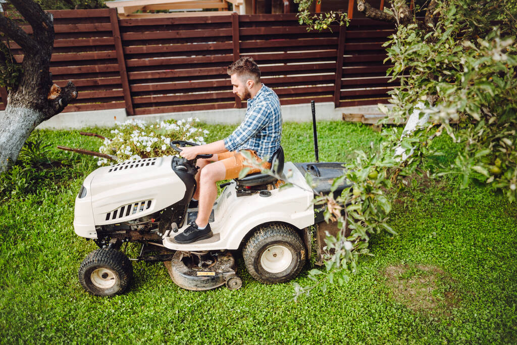 Porträt eines Arbeiters mit Rasenmäher-Traktor - Foto, Bild
