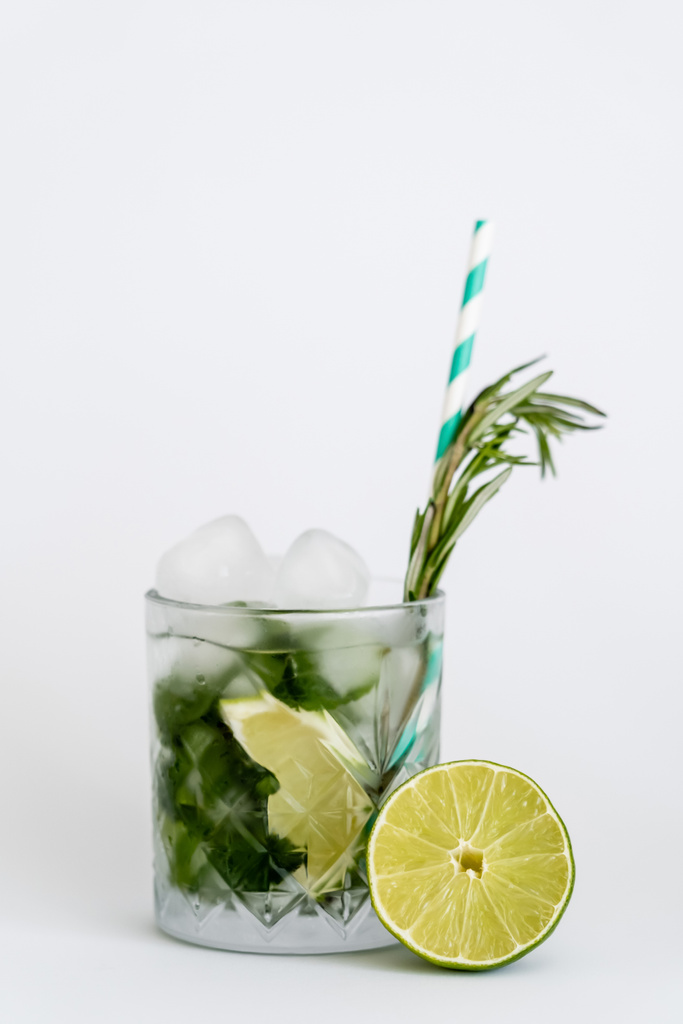 cool faceted glass with mojito, straw and ice cubes isolated on white  - Foto, Imagen