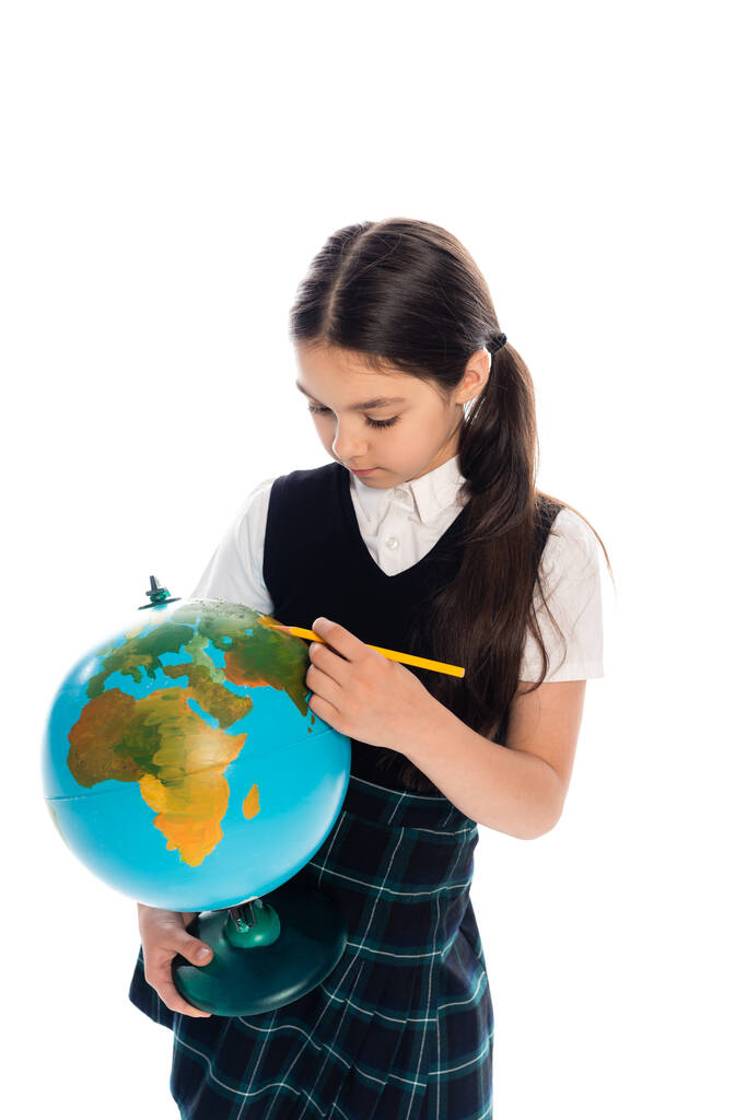 Colegial sosteniendo lápiz cerca de globo aislado en blanco  - Foto, imagen