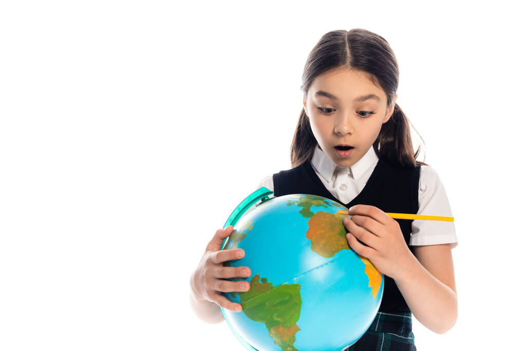 Scioccato scolaro in possesso di matita e globo isolato su bianco  - Foto, immagini