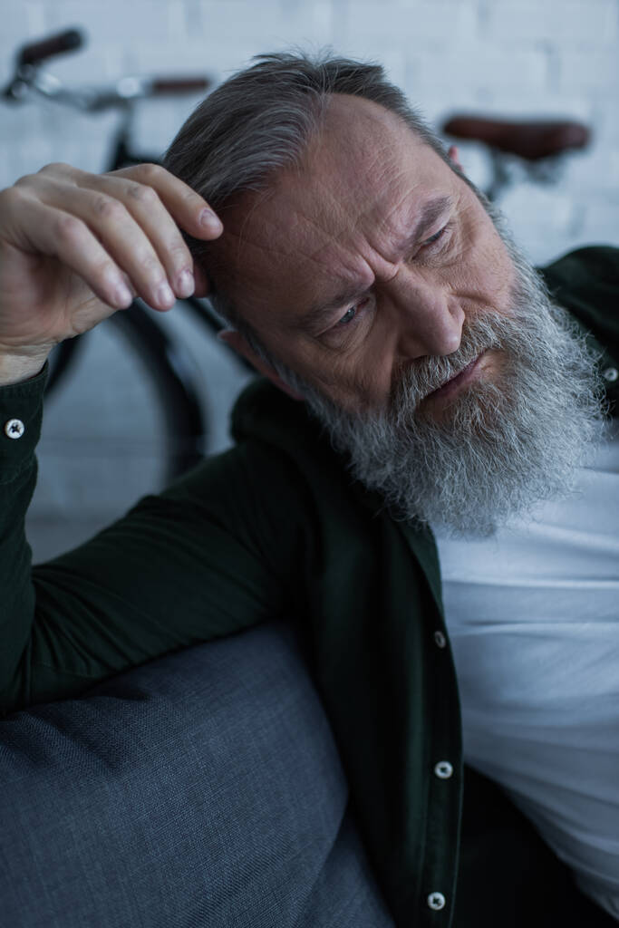 upset senior man with beard looking away while suffering crisis  - Photo, Image
