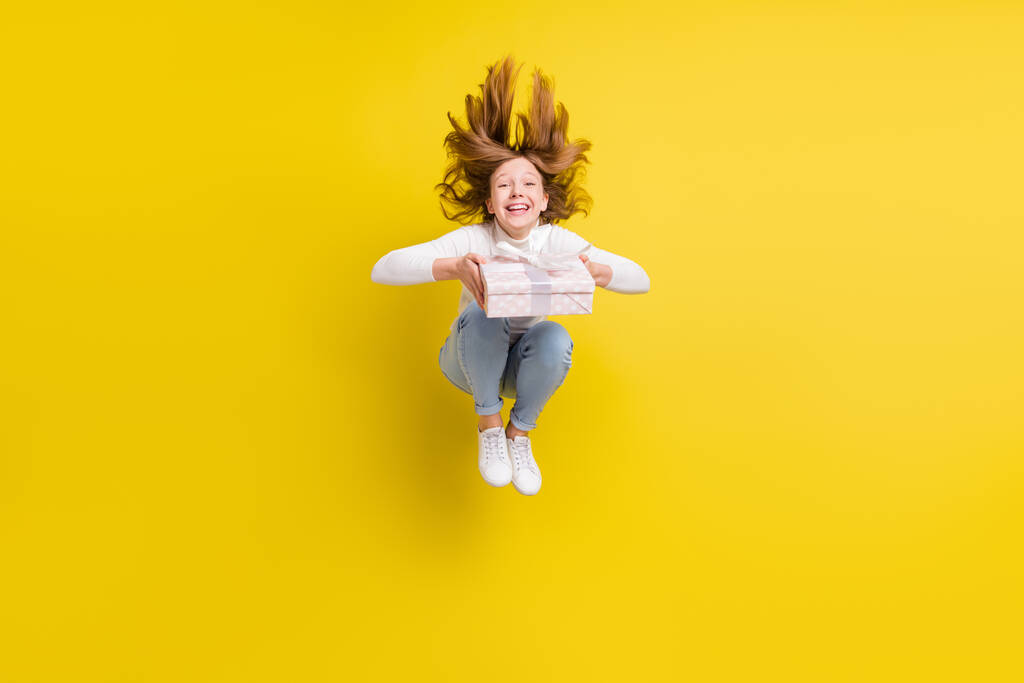Foto corpo pieno di felice bruna giovane ragazza salto capelli volare tenere presente casella isolata su sfondo di colore giallo. - Foto, immagini