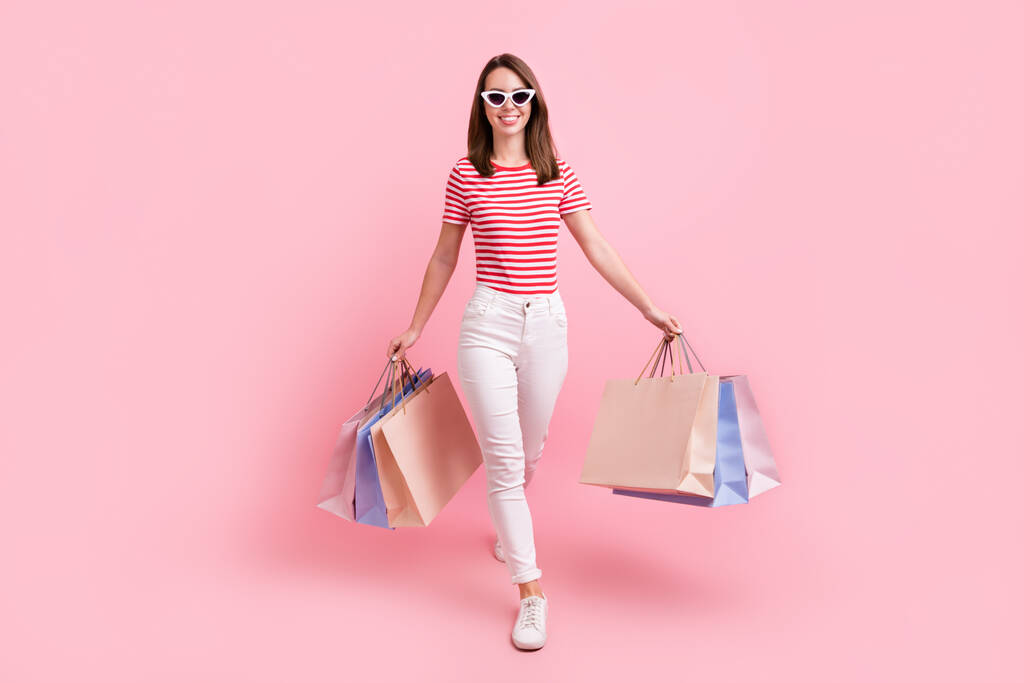 Volledige lengte foto van jong meisje gelukkig positieve glimlach ga lopen stap winkel uitverkoop tassen geïsoleerd over pastel kleur achtergrond. - Foto, afbeelding