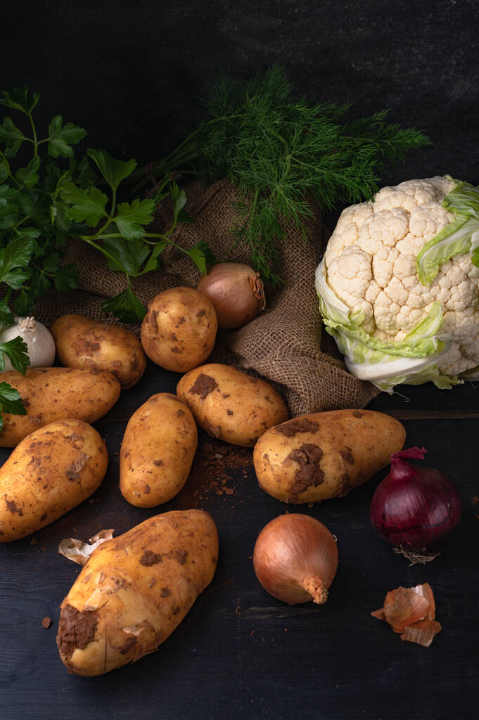 La pomme de terre, le chou, les oignons et les verts sur une table en bois - Photo, image