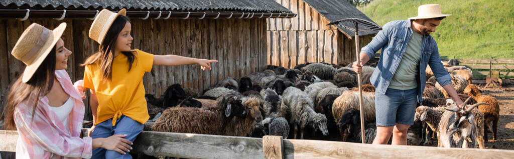 fille en chapeau de paille pointant vers papa travaillant avec le troupeau dans le corral, bannière - Photo, image