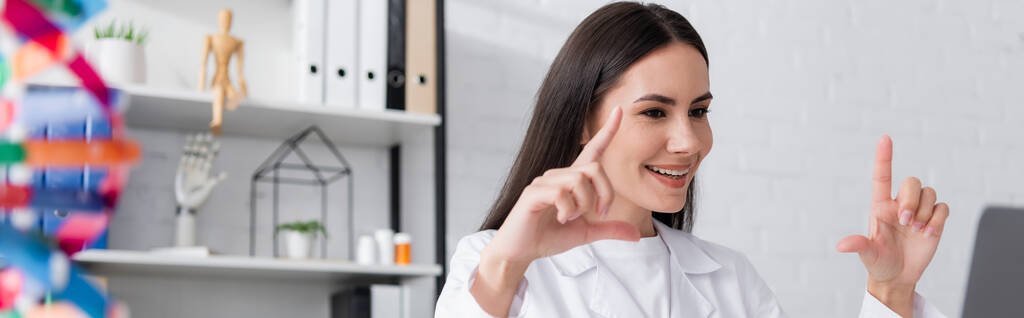 Θετική gesturing γιατρός κατά τη διάρκεια online διαβούλευση για φορητό υπολογιστή στην κλινική, πανό  - Φωτογραφία, εικόνα