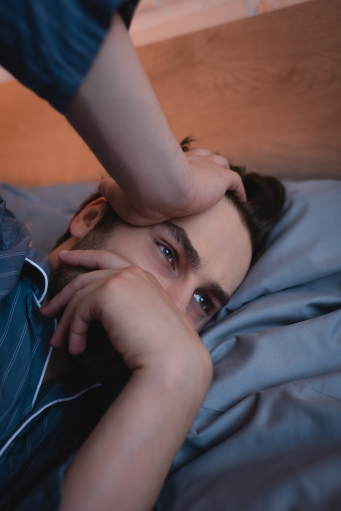 Man in pajama suffering from sleeplessness in bedroom  - Photo, Image