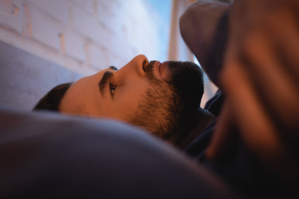 Uomo preoccupato con disturbi del sonno sdraiato sul letto di notte  - Foto, immagini