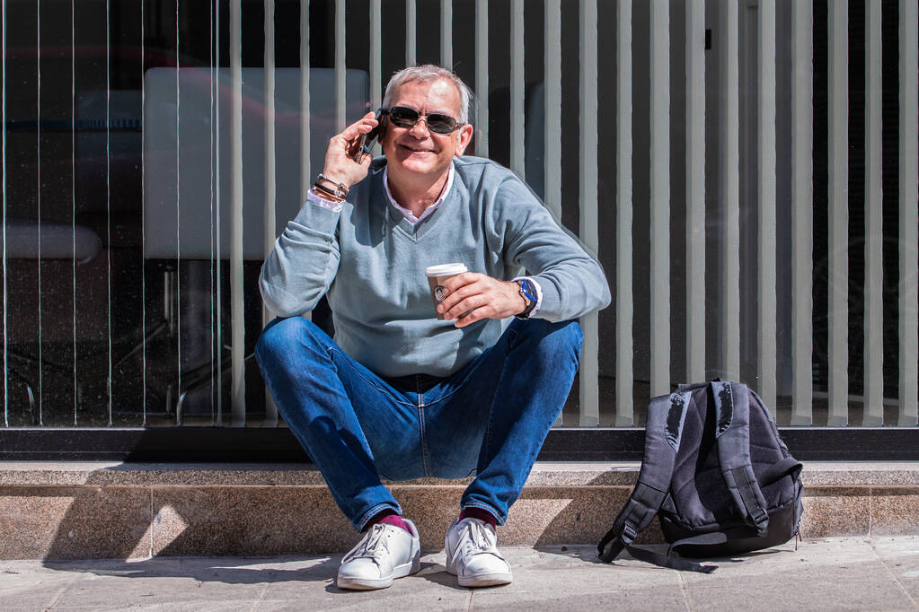 Σχετιζόμενος τουρίστας με σακίδιο που πίνει καφέ και χρησιμοποιεί κινητό τηλέφωνο - Φωτογραφία, εικόνα