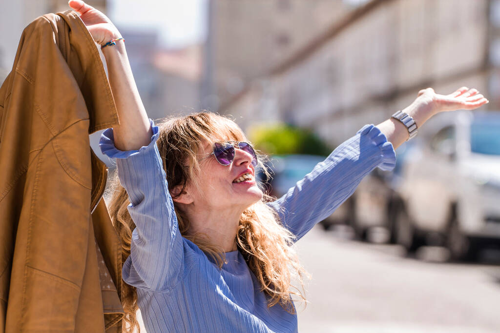 mujer feliz relajada con los brazos levantados en las calles de la ciudad - Foto, Imagen