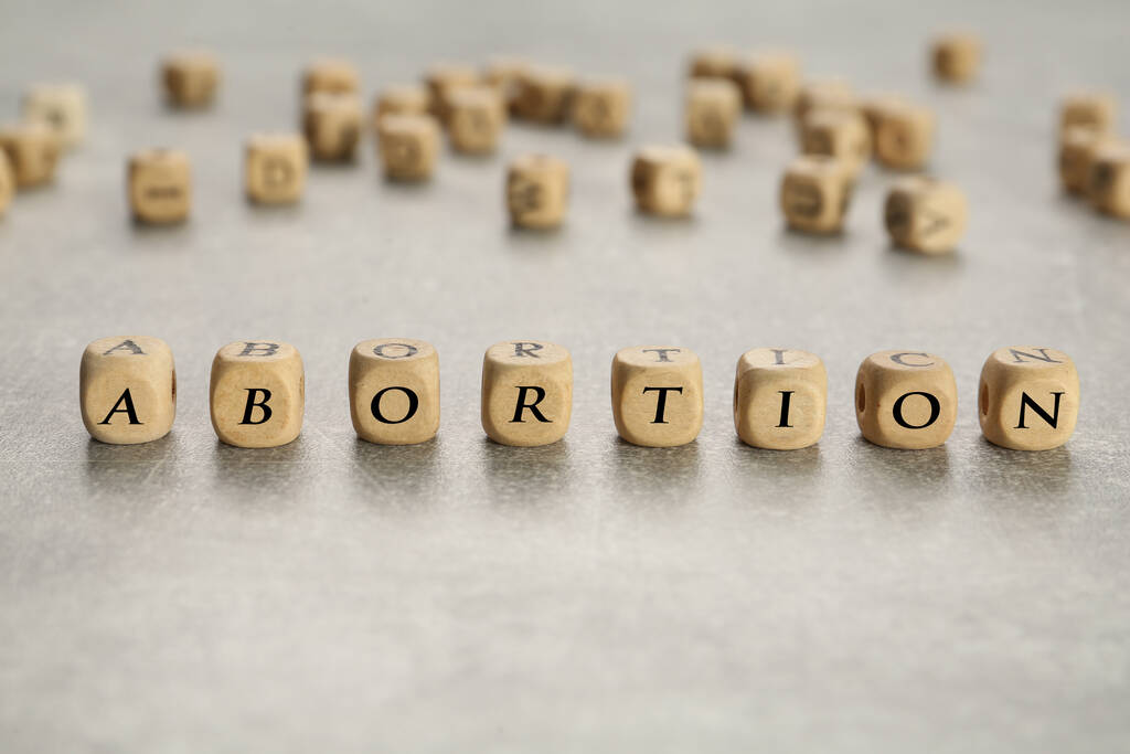 Word Abortion made of wooden cubes on grey table, closeup - Photo, Image