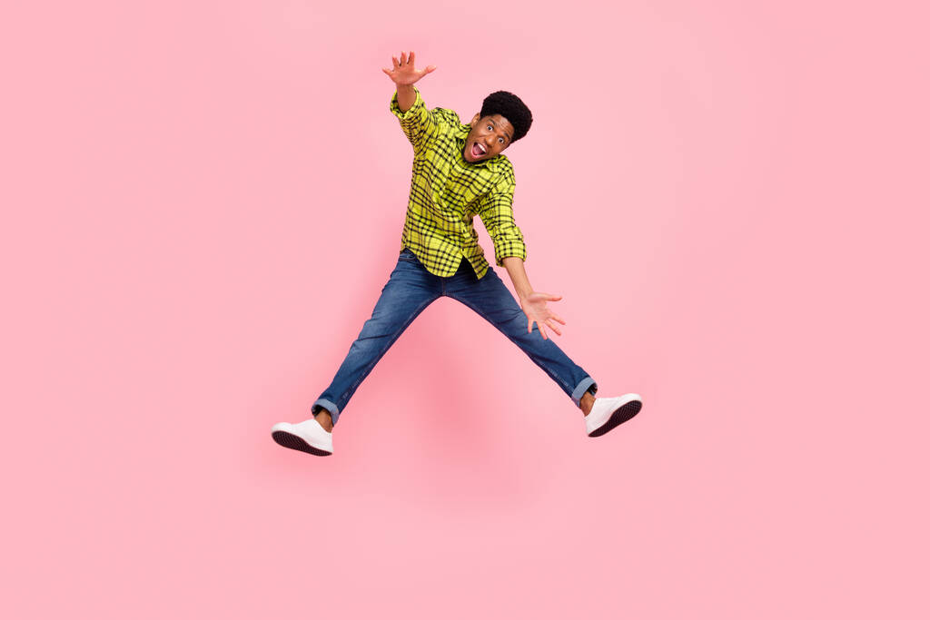 Plná délka fotografie mladých legrační brunetka chlap skok nosit košili džíny tenisky izolované na růžovém pozadí. - Fotografie, Obrázek