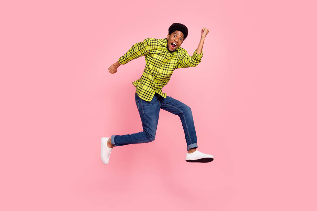 Full size foto van millennial funky brunette guy run slijtage shirt jeans sneakers geïsoleerd op roze achtergrond. - Foto, afbeelding