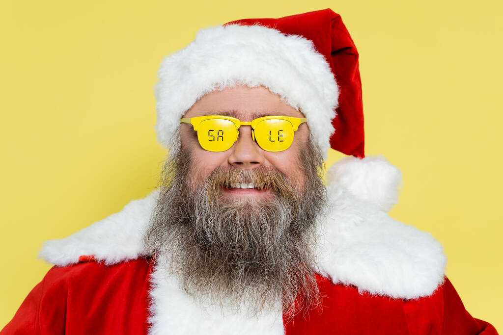 усміхнений і пухкий чоловік в різдвяному костюмі і окулярах з продажем, написи ізольовані на жовтому
 - Фото, зображення