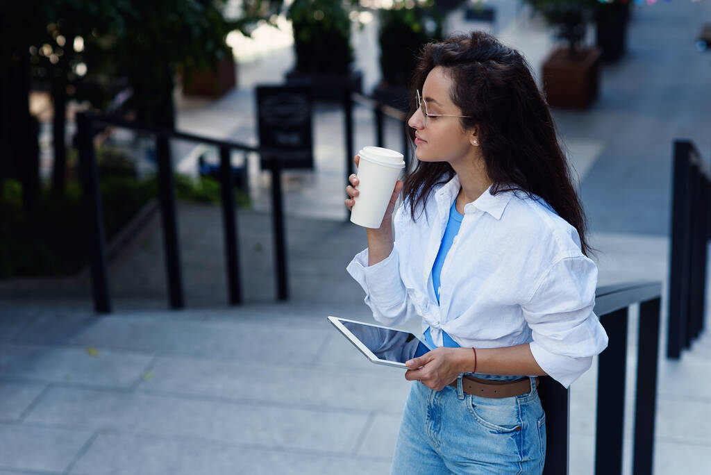 Business nainen kuppi kuumaa maukasta kahvia seisoo portaissa lähellä business centrum. Teknologiapäällikkö. - Valokuva, kuva