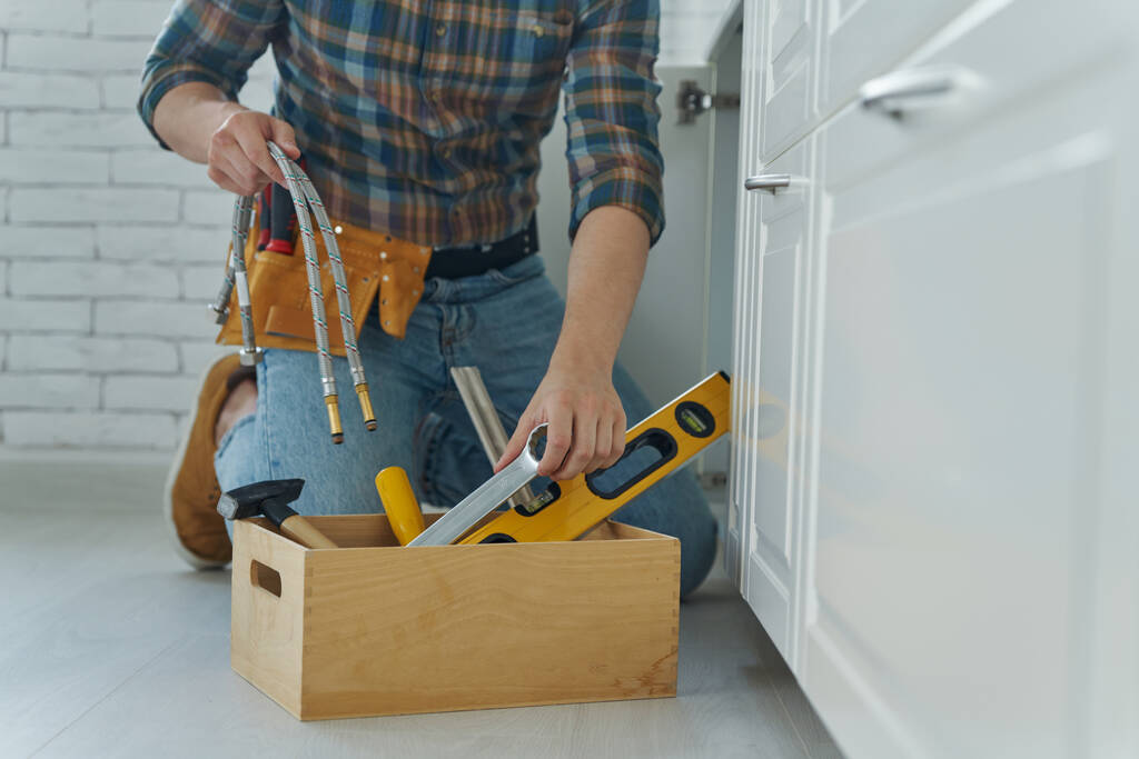 Close-up of handyman preparing tools to repair kitchen sink - 写真・画像