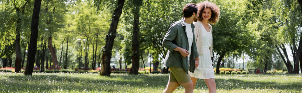 onnellinen nuori pari ottaa päivämäärä kävellessään vihreässä puistossa, banneri - Valokuva, kuva