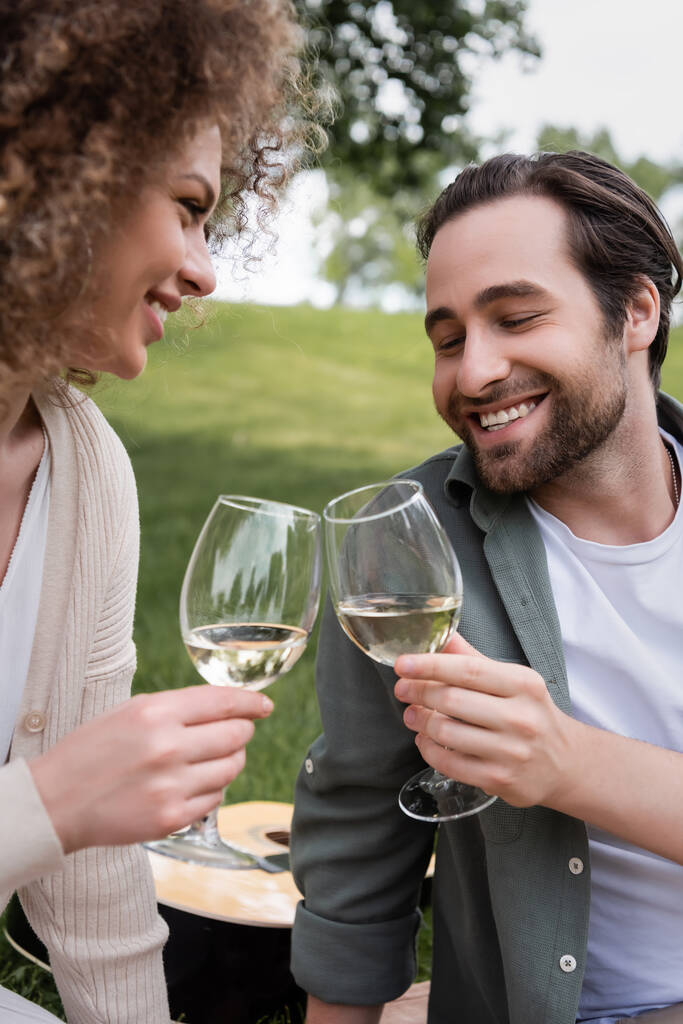 happy young couple clinking glasses of wine during picnic - Foto, Imagem