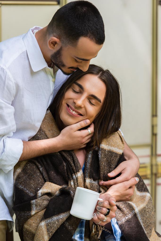 φροντίδα ομοφυλόφιλος άντρας αγκαλιάζει χαρούμενος φίλος σε κουβέρτα κάθεται κοντά σε van - Φωτογραφία, εικόνα