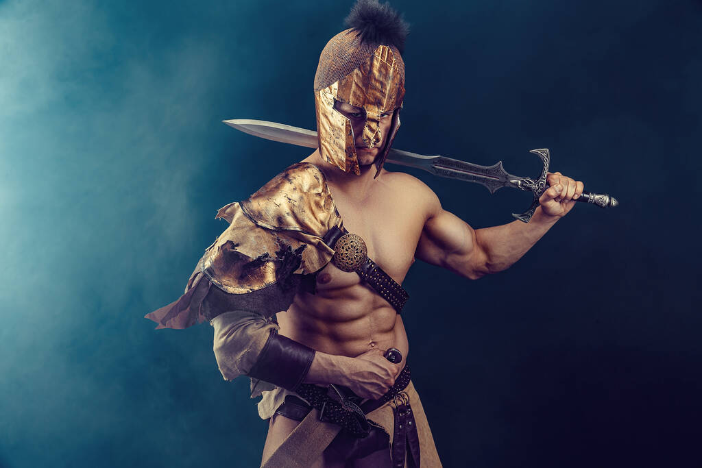 Portrait of handsome muscular gladiator with sword. Isolated. Studio shot. Dark background.  - Foto, imagen