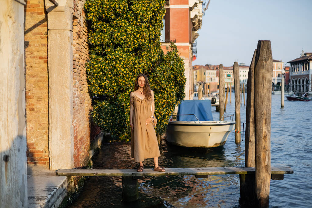 Беременная женщина стоит на пирсе в Венеции  - Фото, изображение
