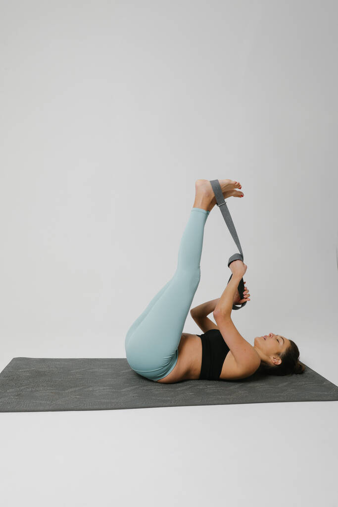 Mujer joven practicando yoga aislada sobre fondo blanco. Concepto de vida sana y equilibrio natural entre salud corporal y mental. - Foto, imagen