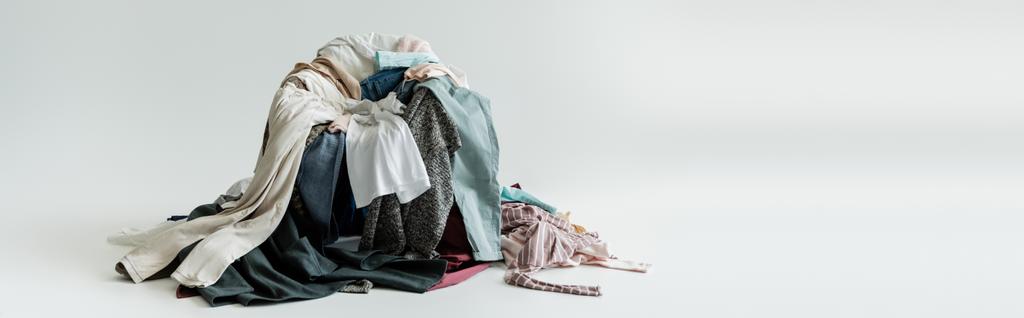 desorden de diferentes ropas sobre fondo gris con espacio de copia, banner - Foto, imagen