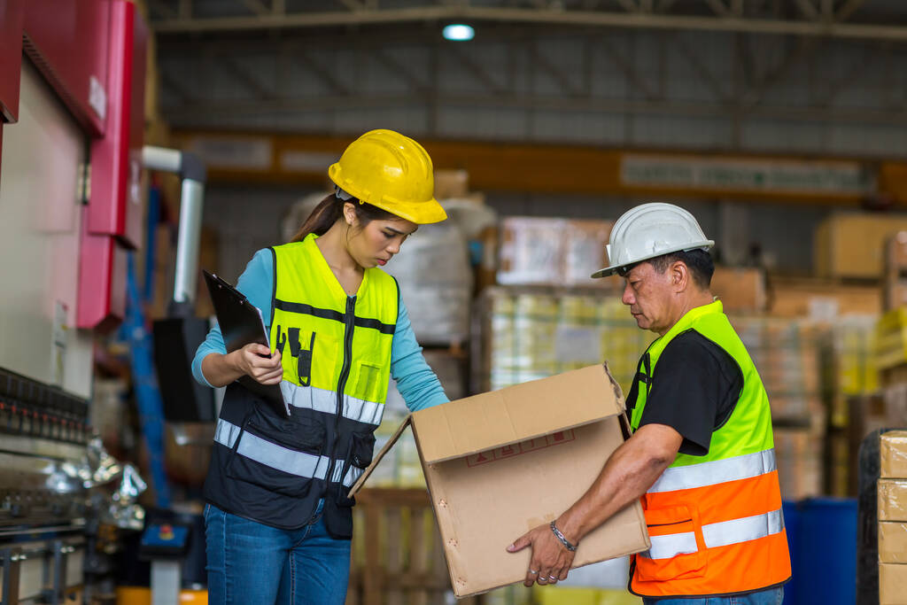 portrait of male worker and man in uniform working with clipboard in warehouse - Foto, Imagem