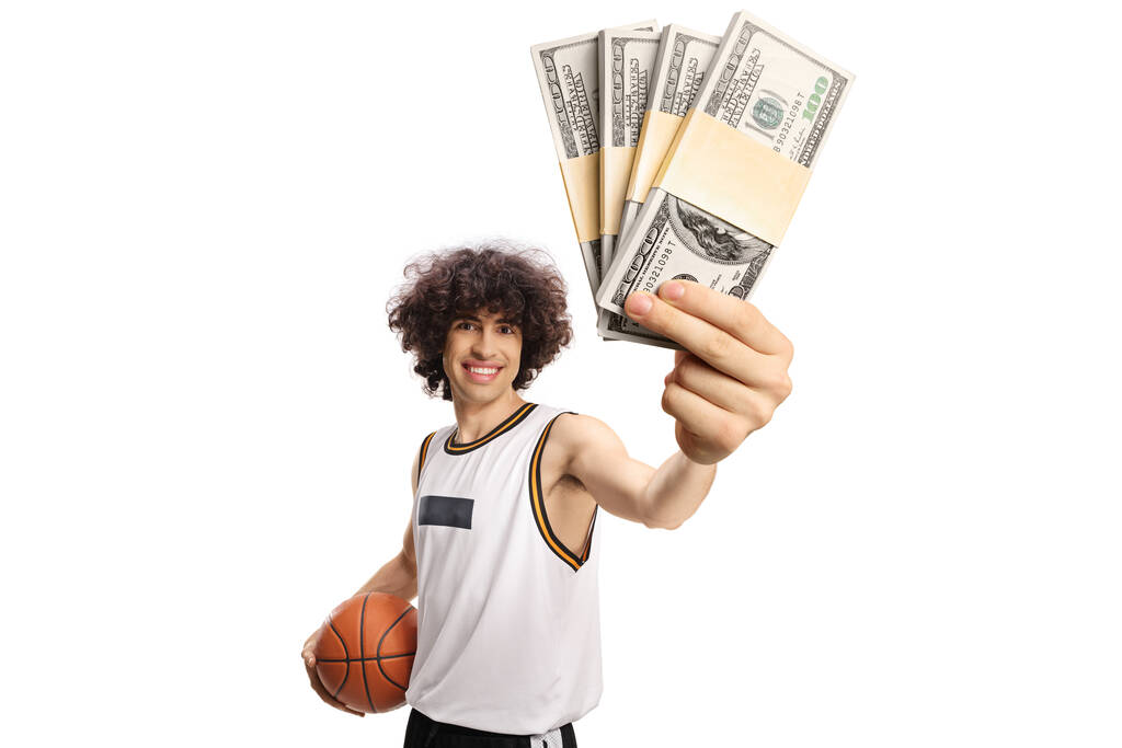 Basketball player holding a ball and money banknotes isolated on white background - Photo, Image