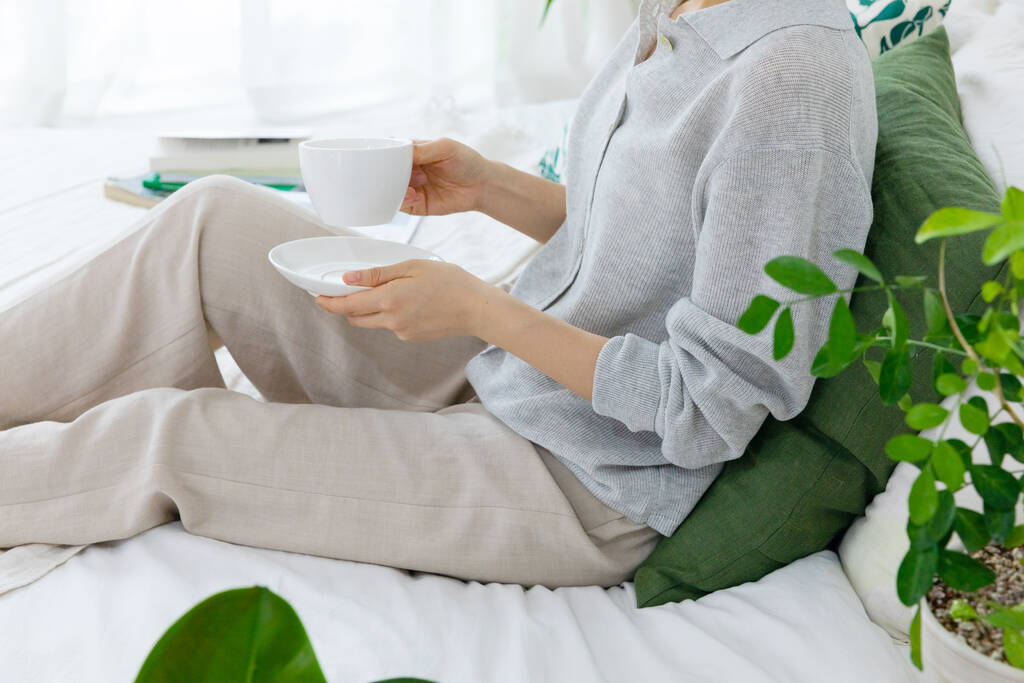 woman with cup of tea on bed - Photo, Image
