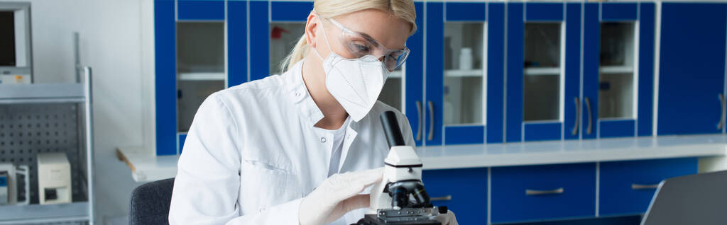 Scientist in goggles and protective mask using microscope in lab, banner  - Foto, Imagen
