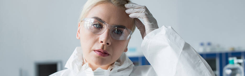 Ученый в защитных очках и костюмах, смотрящий в лабораторию, баннер  - Фото, изображение