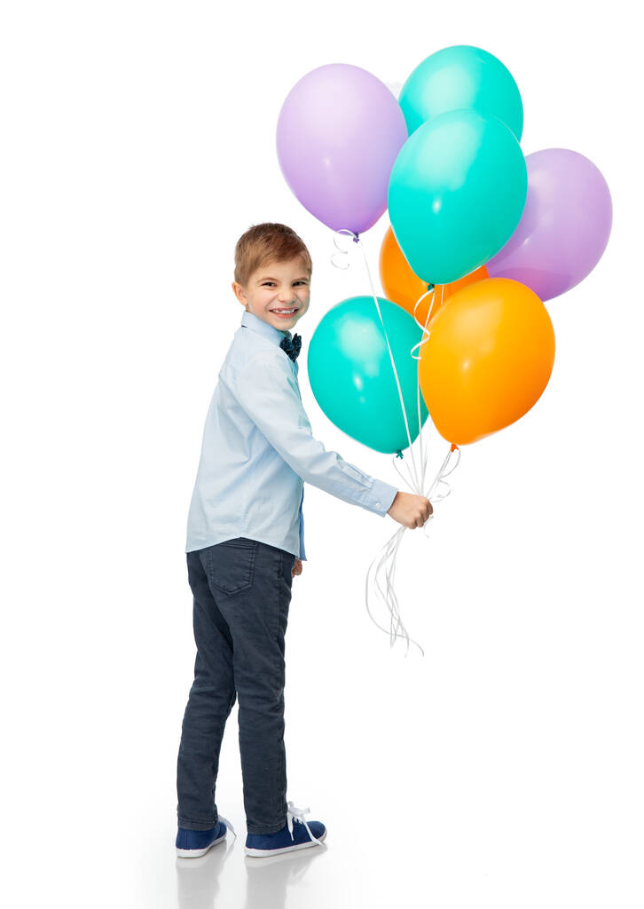 születésnap, gyermekkor és emberek koncepció - portré mosolygós kisfiú lufikkal fehér háttér - Fotó, kép