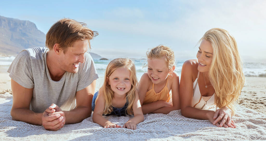 Πορτρέτο μιας ανέμελης οικογένειας που χαλαρώνει και δένεται στην παραλία. Χαρούμενα κοριτσάκια που διασκεδάζουν με τους γονείς τους στις διακοπές. Η μαμά και ο μπαμπάς θαυμάζουν τις κόρες τους σε διακοπές στην παραλία.. - Φωτογραφία, εικόνα