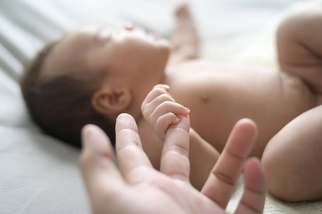 Close of hand holding new born baby's finger - Valokuva, kuva