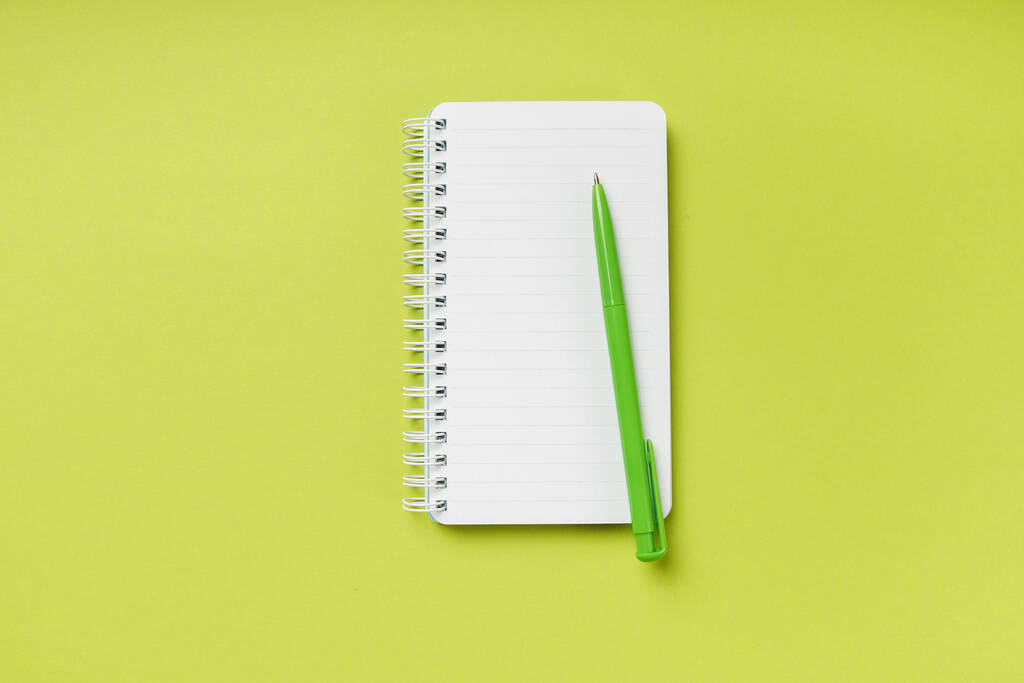 Mockup prázdné jarní notebook a pero na čerstvém zeleném pozadí s kopírovacím prostorem. Horní pohled. - Fotografie, Obrázek